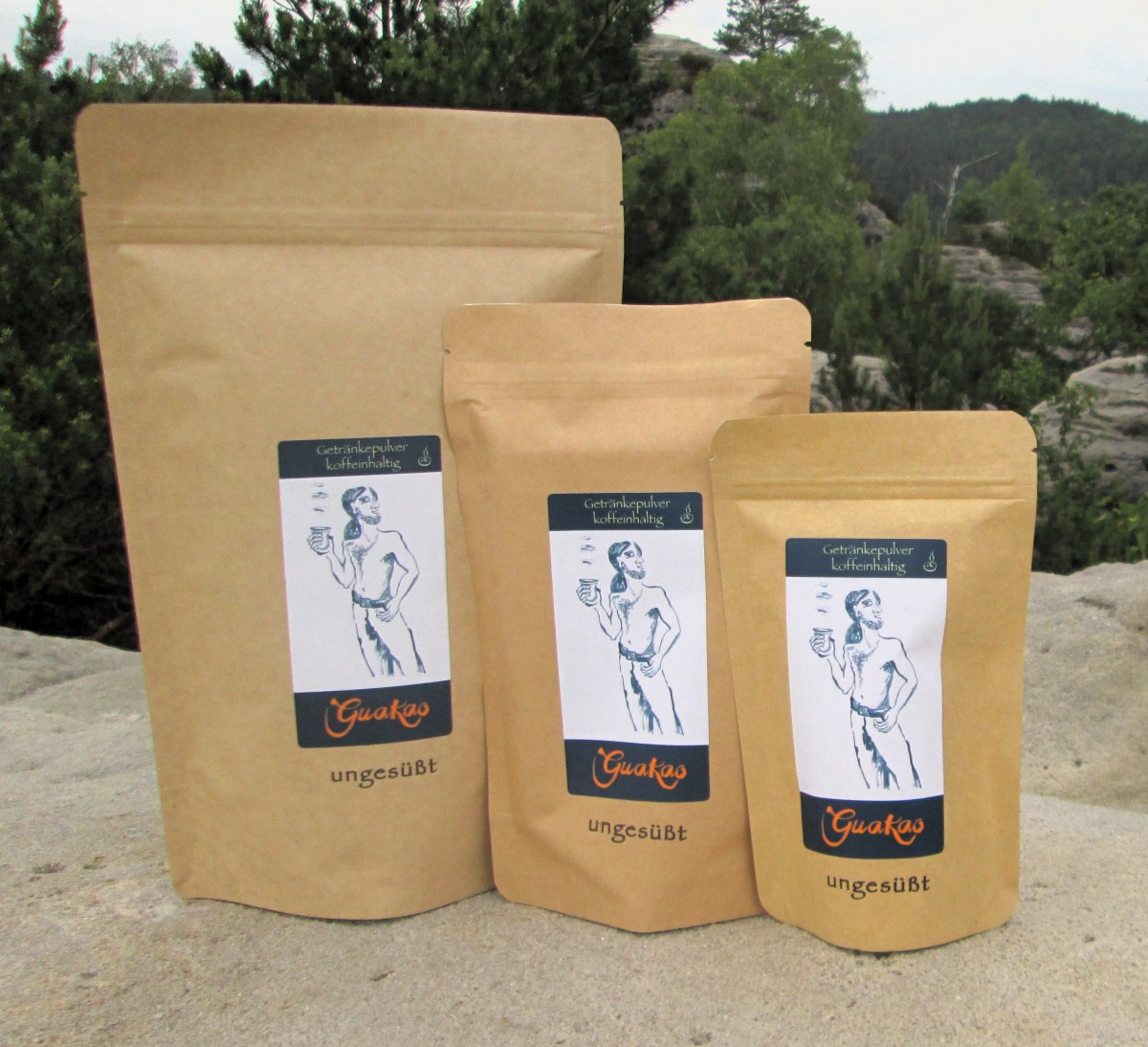 Die 3 Packungsgrößen (600g, 200g,80g) von GuaKao ungesüßt stehen auf einer Felsnase am Papststein in der Sächsischen Schweiz.
